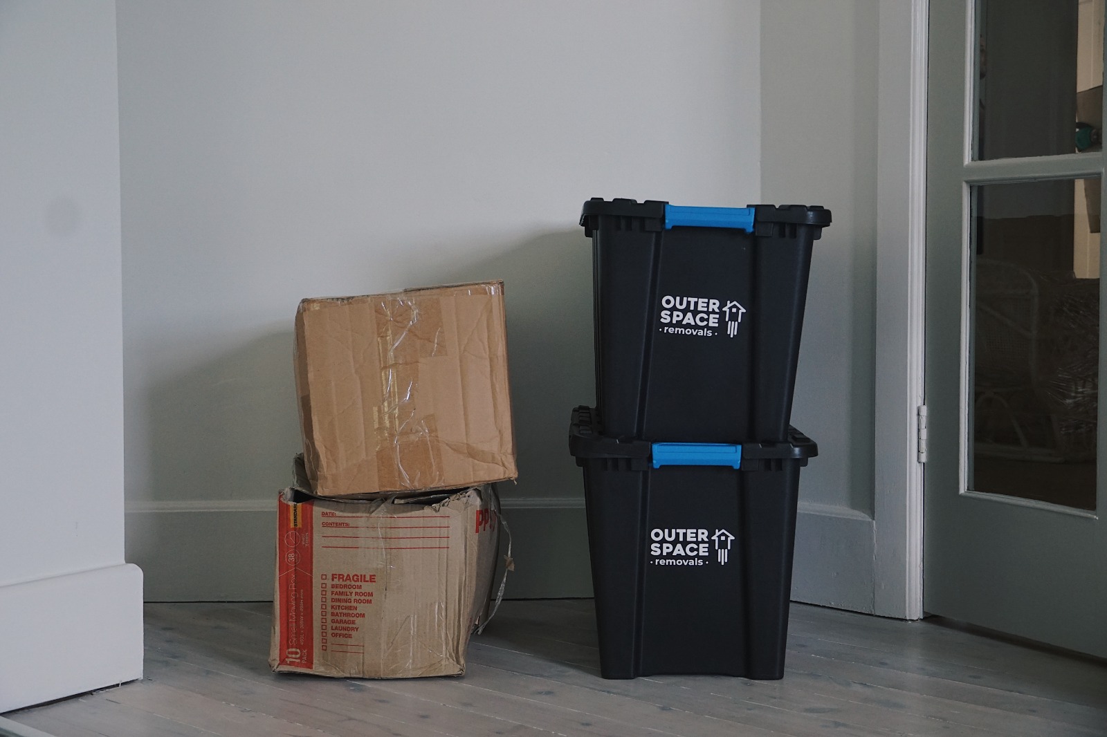 Two Outer Space crates next to two battered cardboard boxes