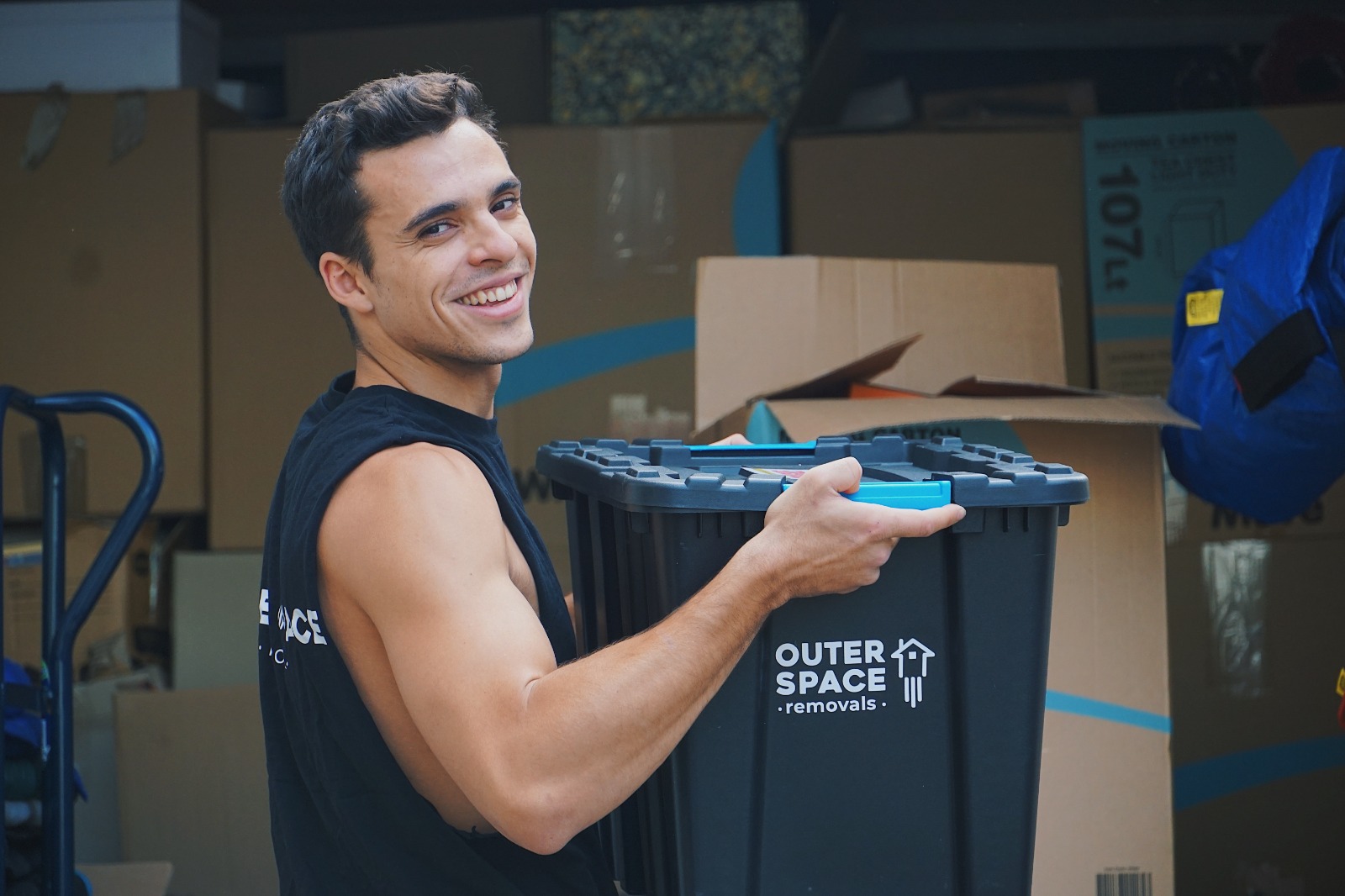 Smiling mover carrying an Outer Space crate