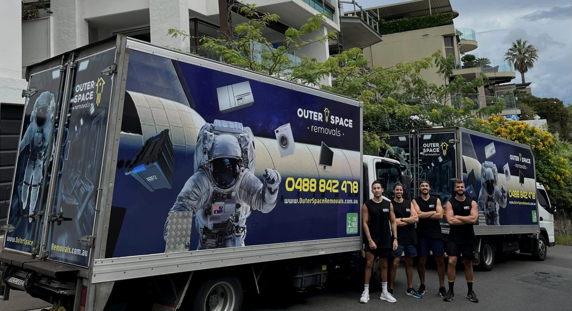 Outer Space Removals removalists in uniform beside their branded removal trucks in Sydney