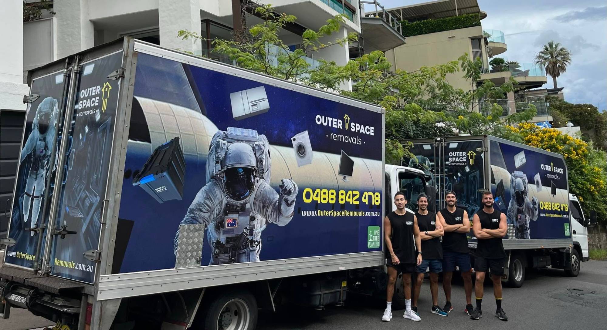 Outer Space crew beside two branded trucks