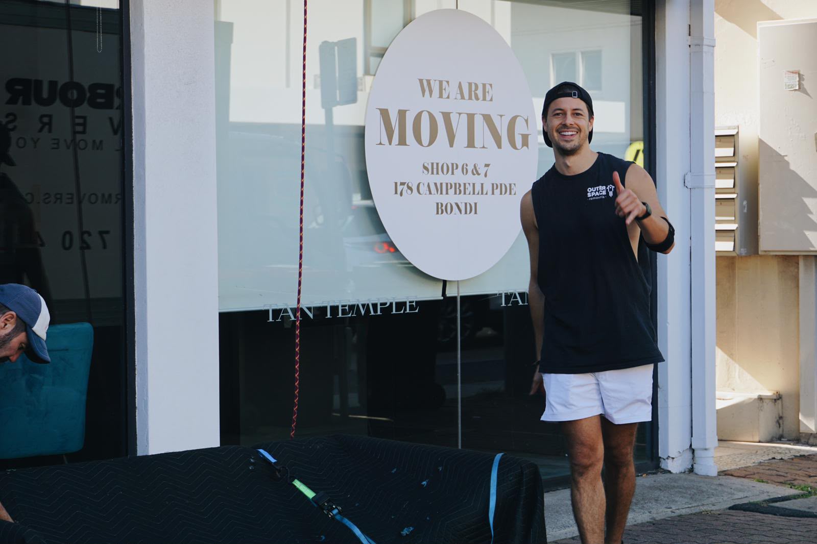 Jay, co-founder of Outer Space Removals, giving a thumbs up outside a shop move on Campbell Parade, Bondi